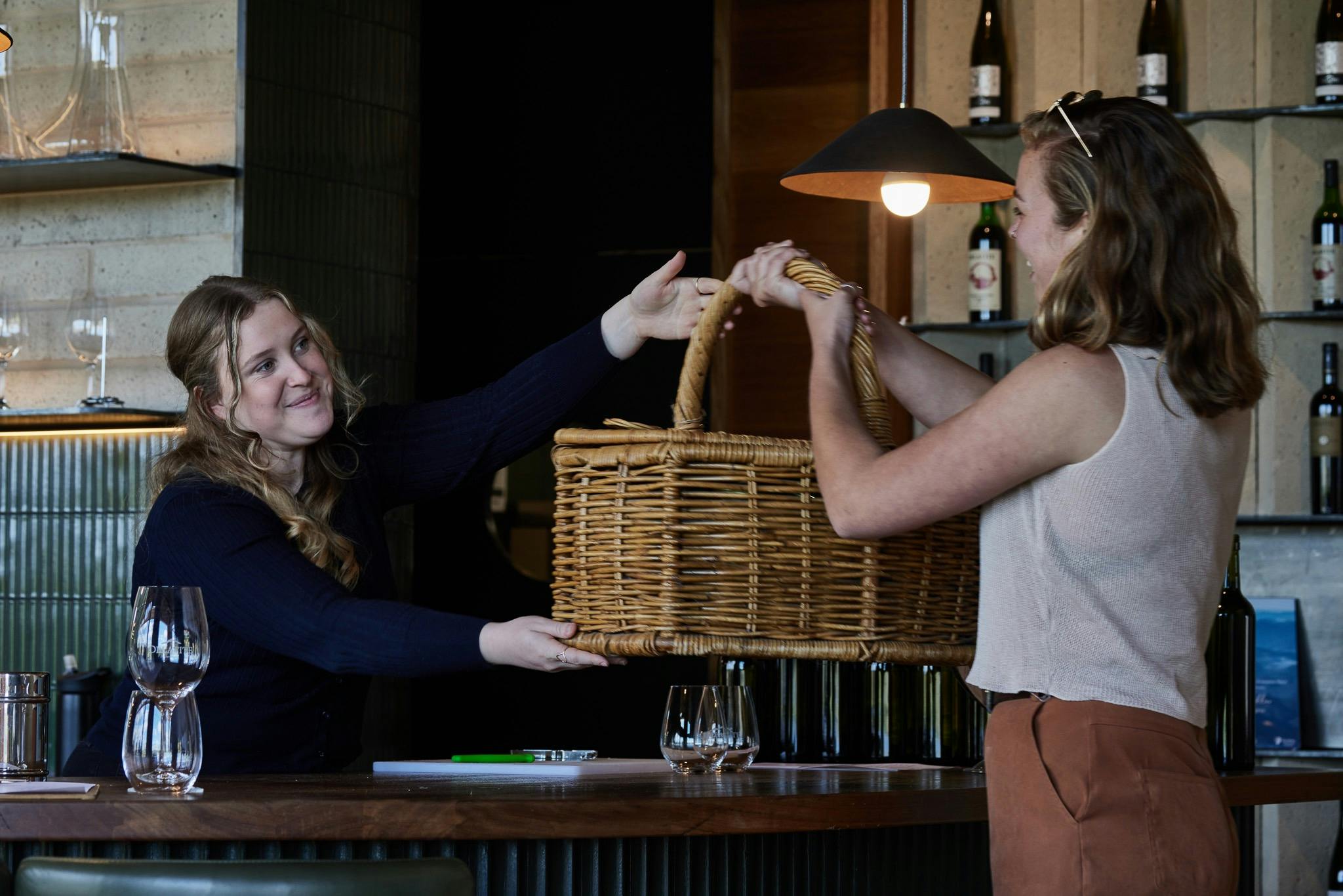 Two people exchanging a picnic hamper