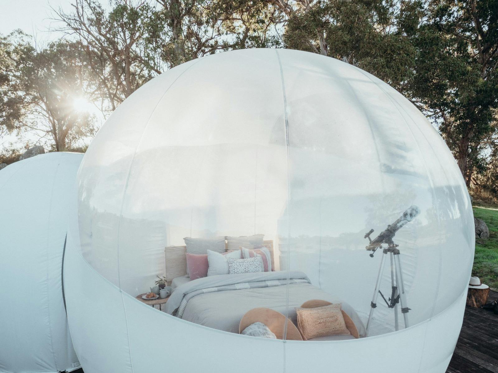 The interior of Captain Thunderbolt Bubbletent with seating, telescope and designer bedding