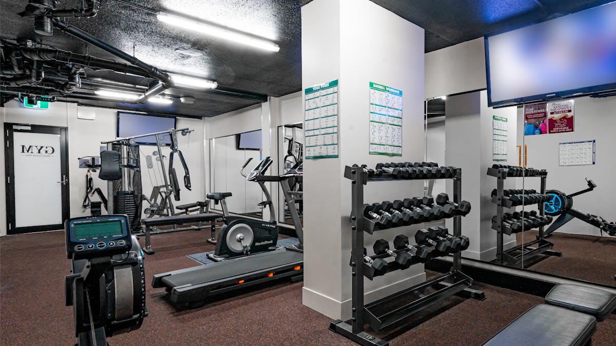 Hotel Gym Facilities featuring a range of different exercise machines, weights, mirrors and TVs