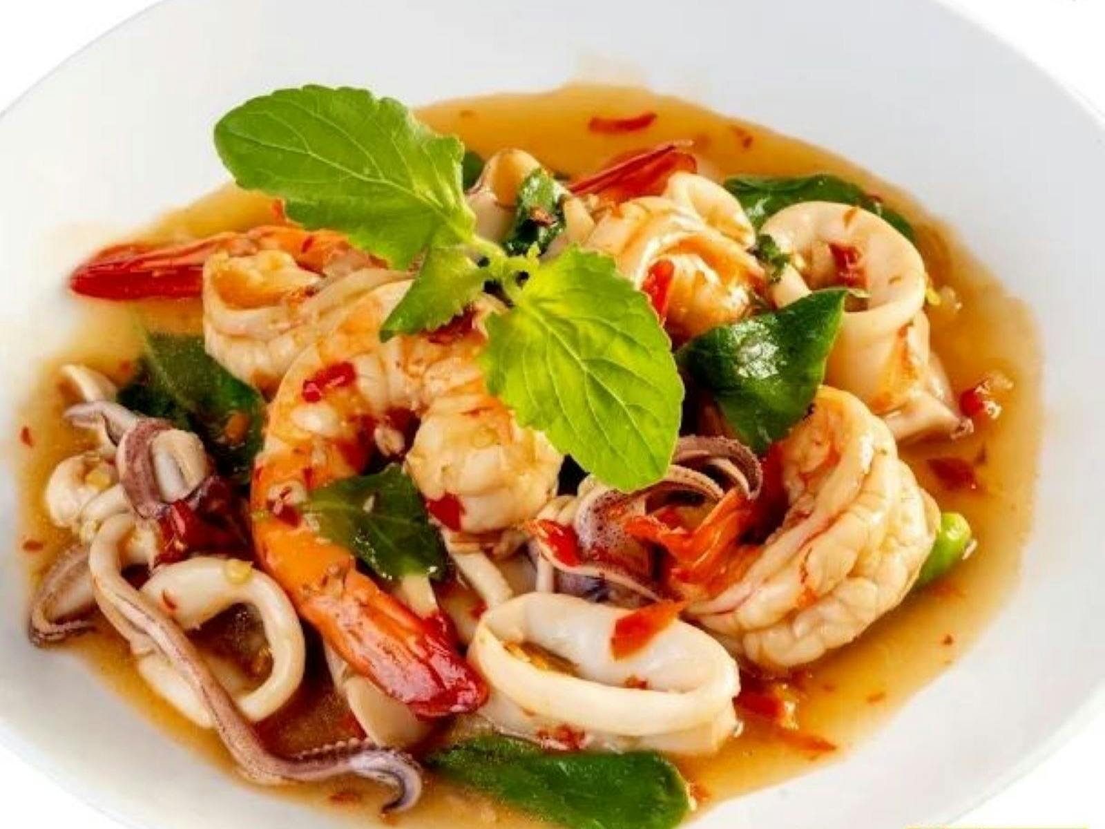 Seafood plat with prawns, scallops and squids decorated with green leaves