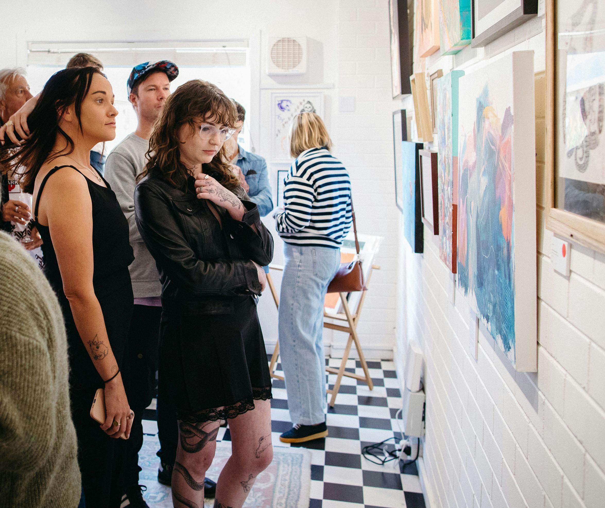 在巷道畫廊的群展開幕式欣賞展牆