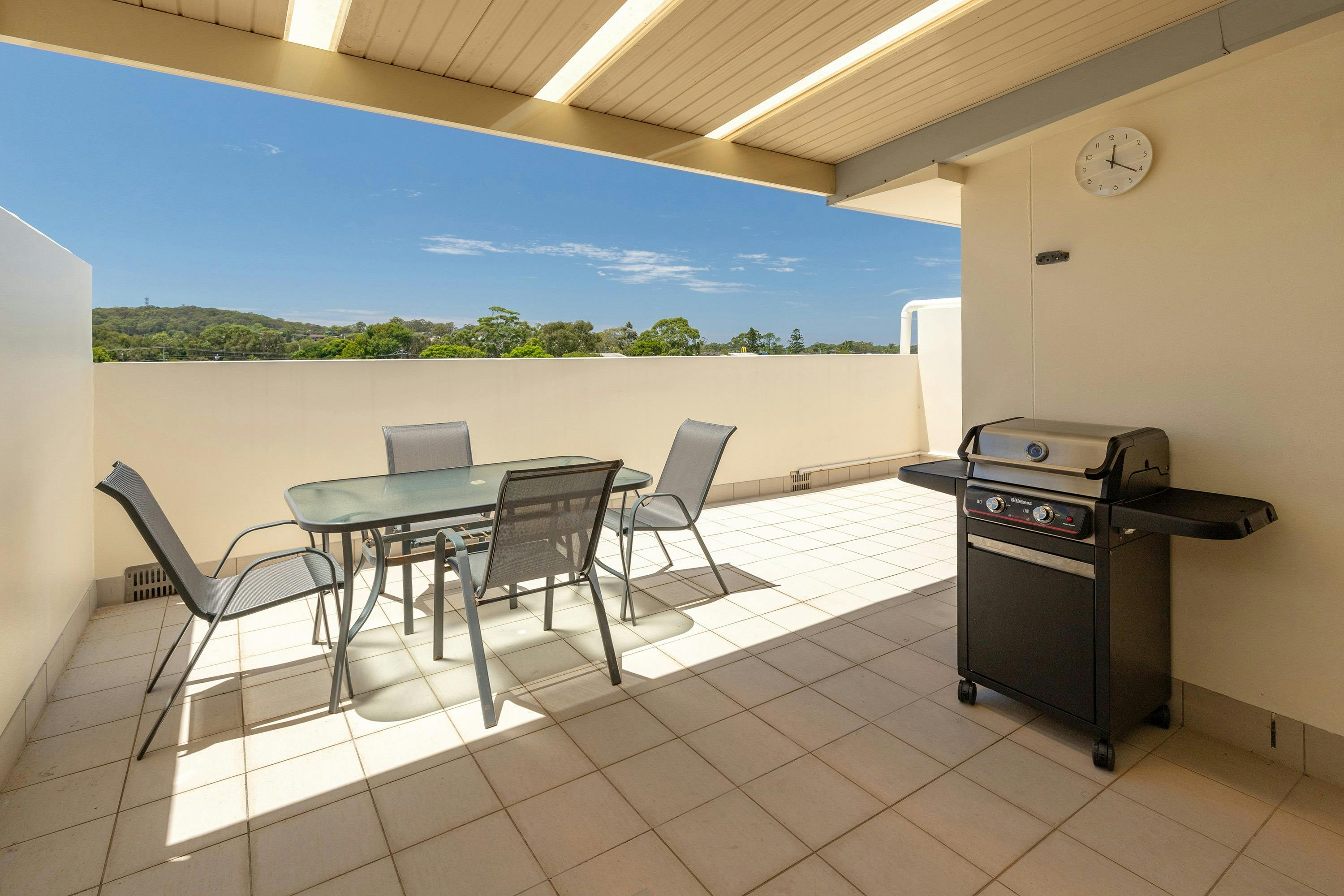 Back balcony with barbeque and dining setting