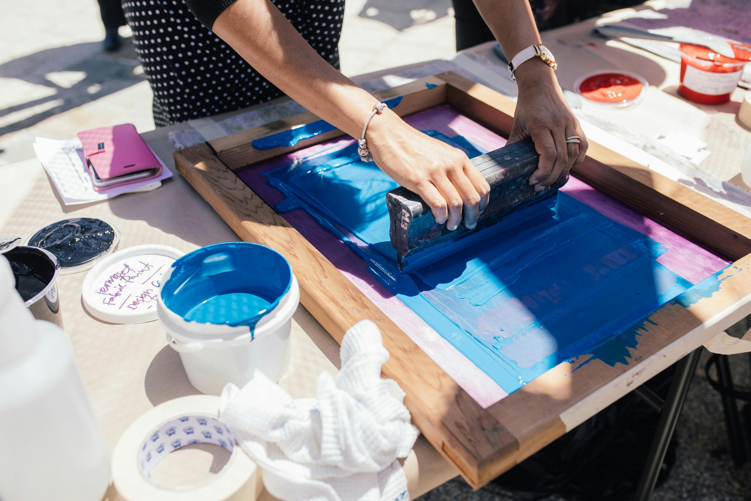 Two women hold a screen flat and squeegee