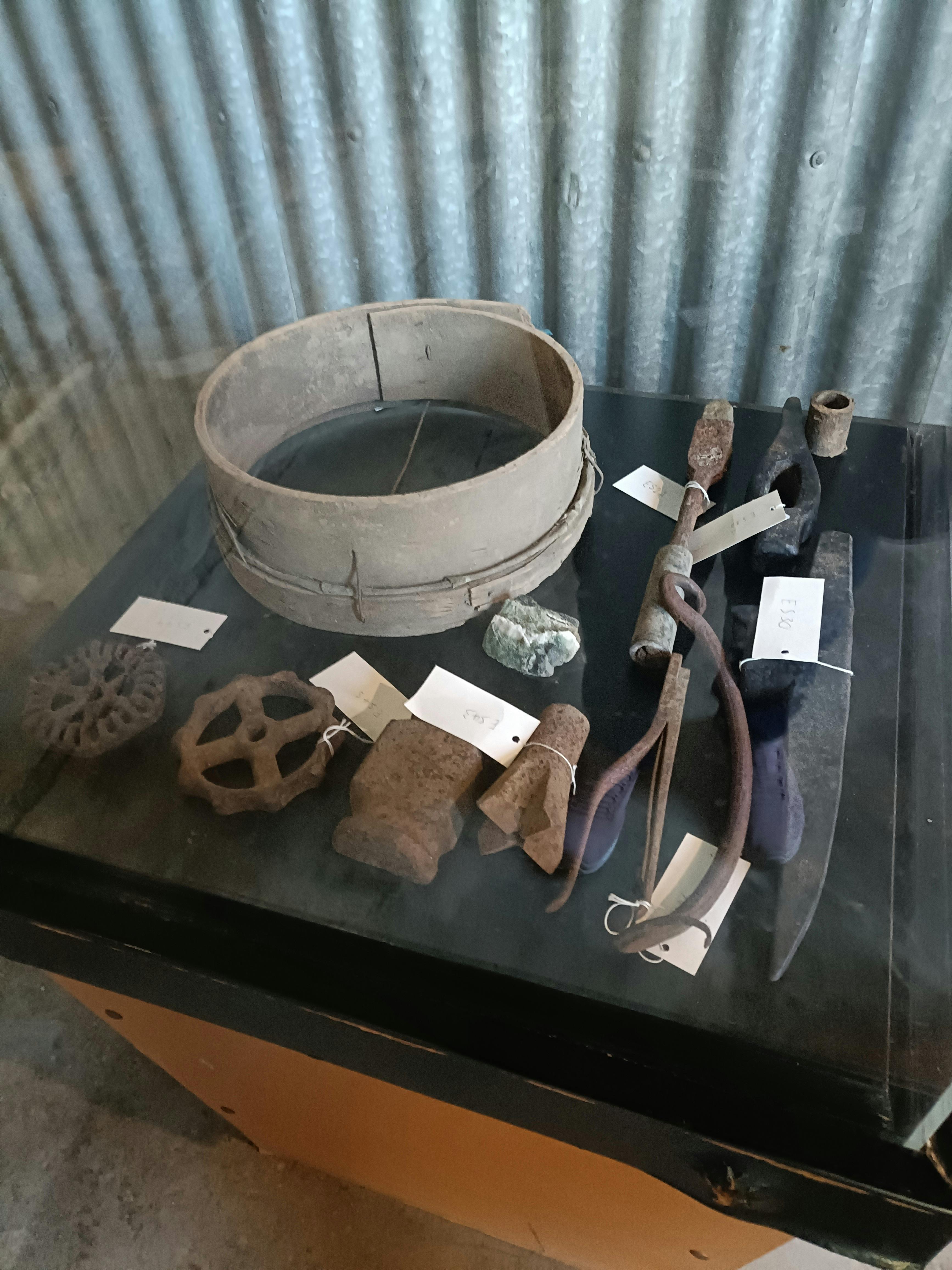 Sieve and mining equipment displayed on table in shed