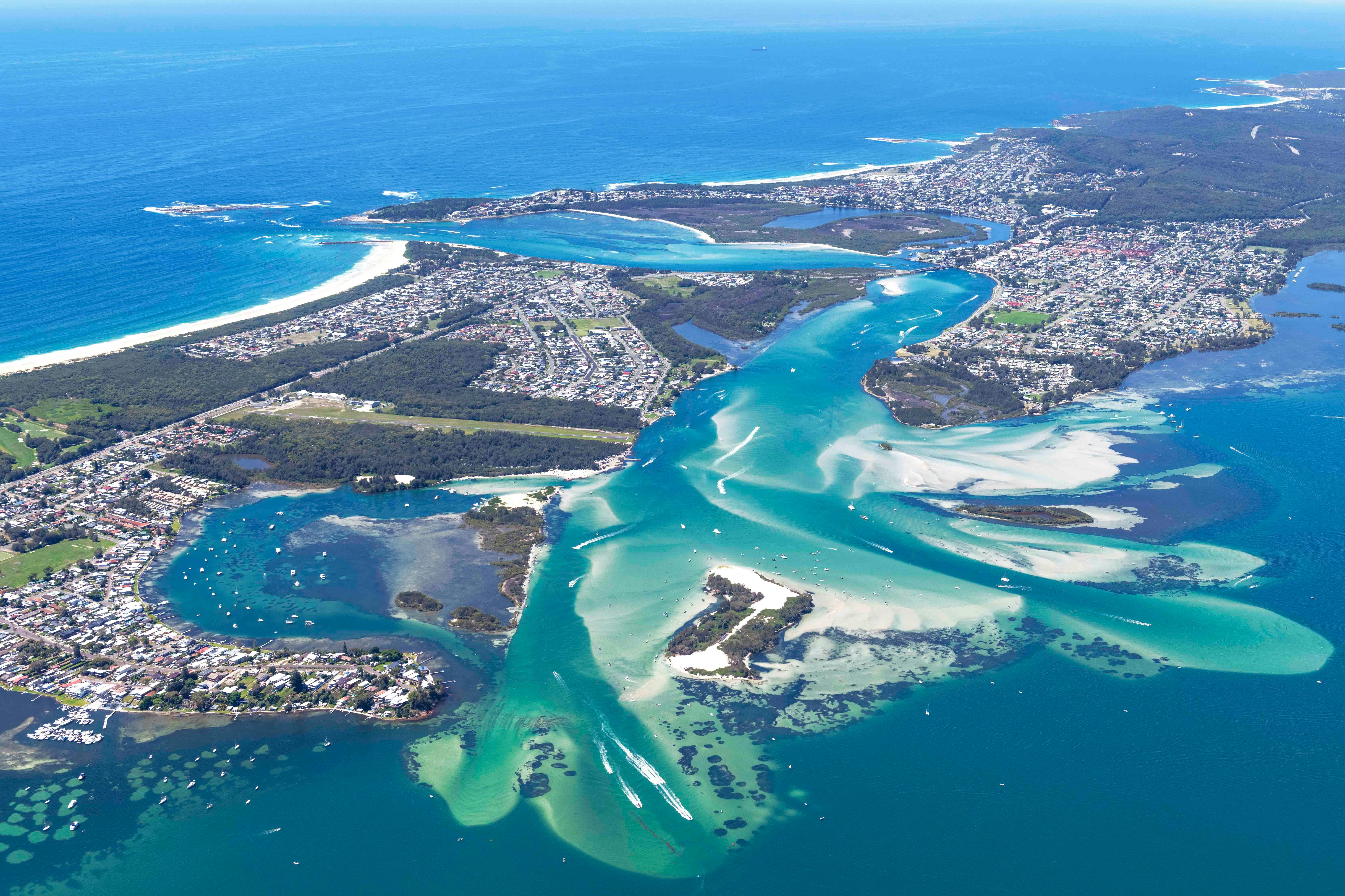 Aerial view of Lake Macquarie NSW with bright turquoise water and surrounding coastline