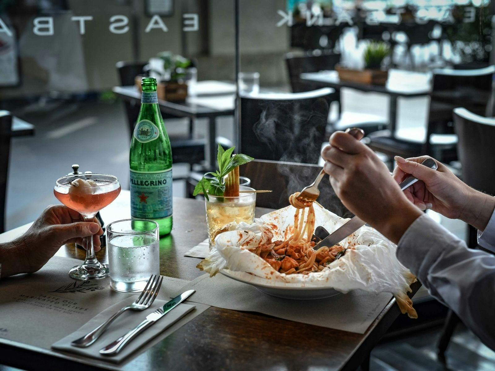 Eastbank Cafe, cozy indoor dining with a signature baked seafood linguine and cocktails