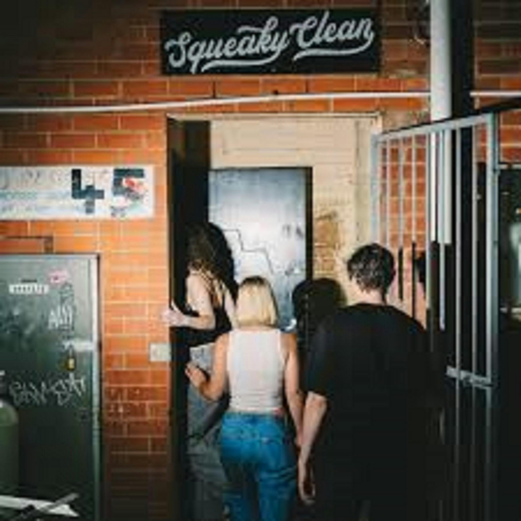 Group of people walking into doorway behind a brick wall