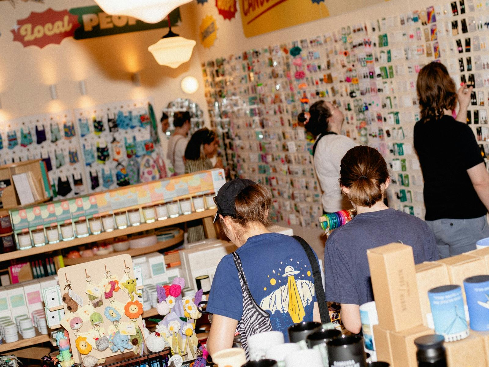 Shoppers exploring a vibrant selection of locally made goods, candles, keychains, and more.