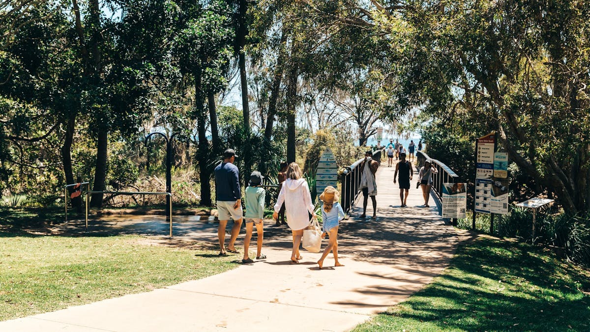 A family of 4 walking through the entrance of the Agnes Water Beach