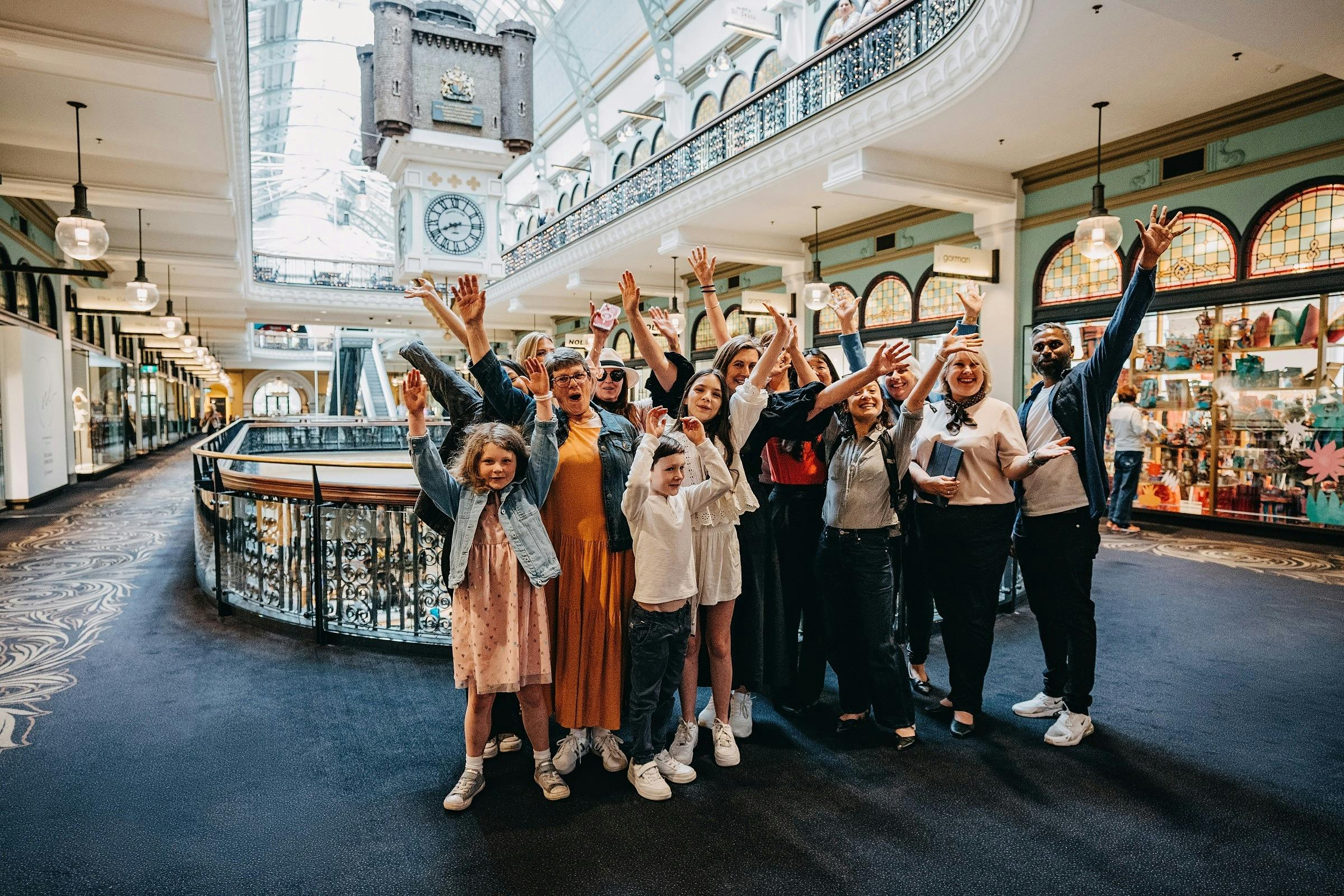A tour group taking a photo in front of the Royal Clock on level one of the QVB