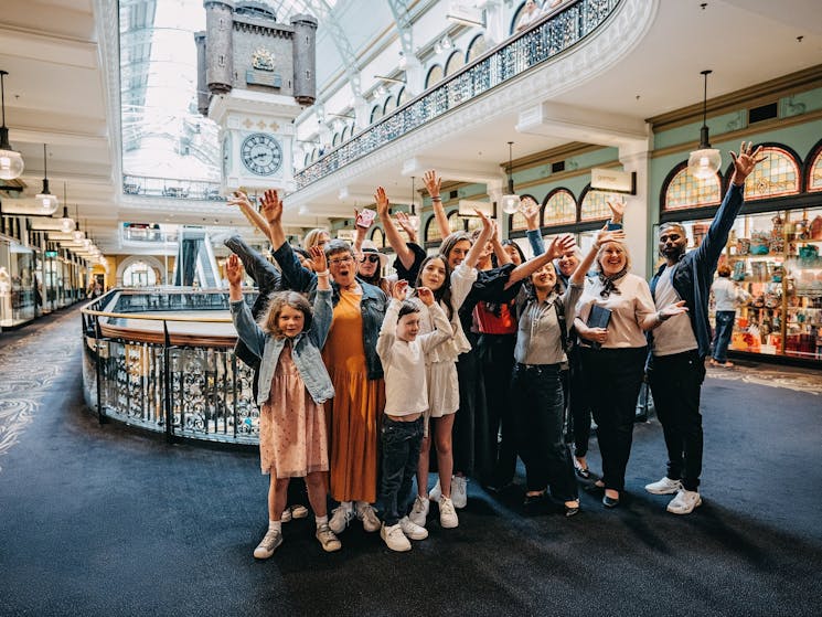 A tour group taking a photo in front of the Royal Clock on level one of the QVB