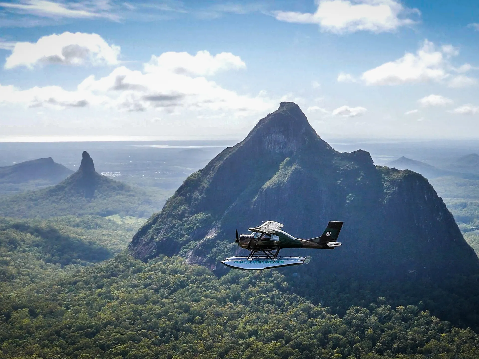 Paradise Seaplanes flies in front of Glasshouse Mountains