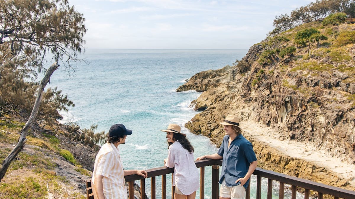 Tourists pausing at the top of the stairs leading down to the beach