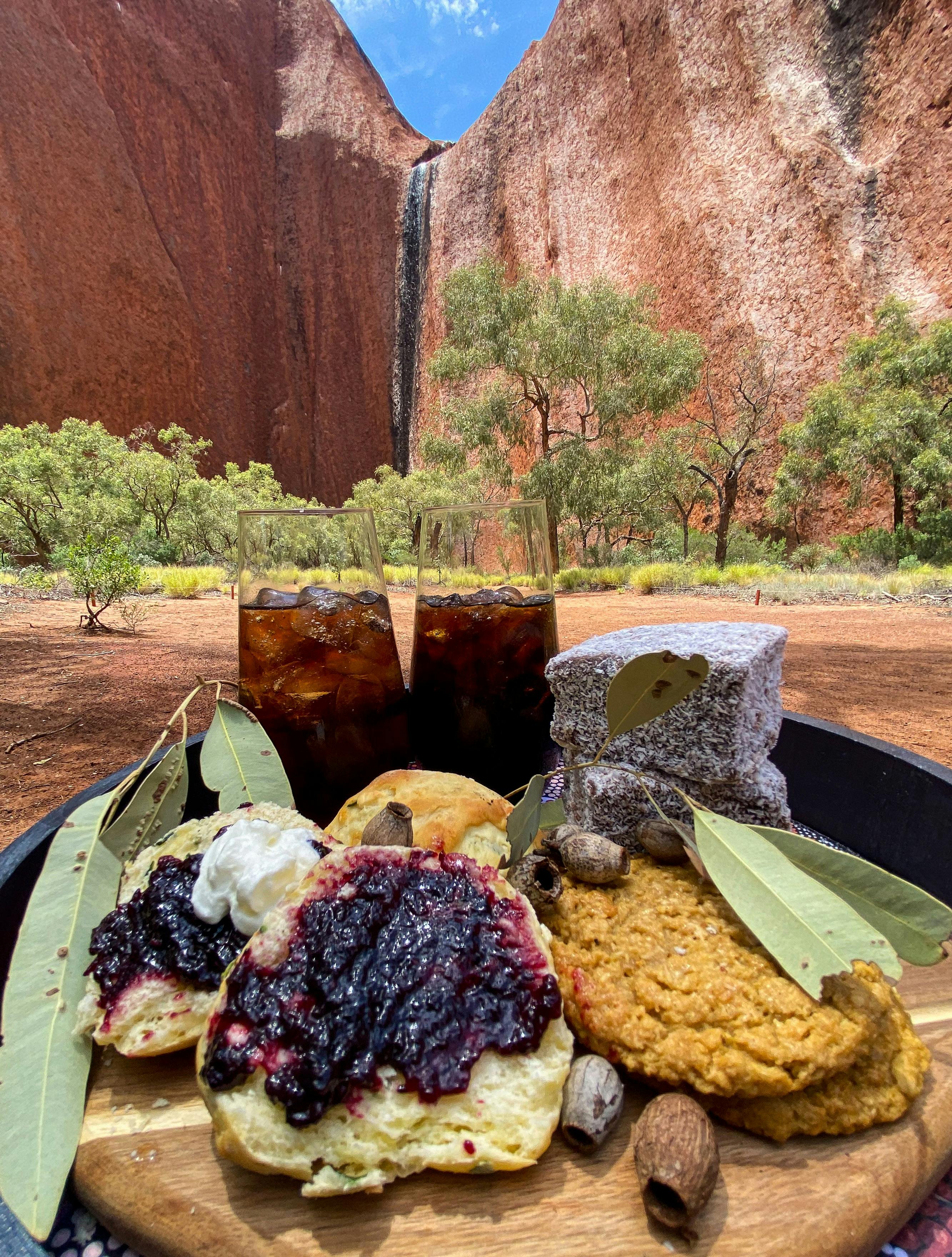 Sparkling iced tea with scones and ANZAC biscuits beside Uluru