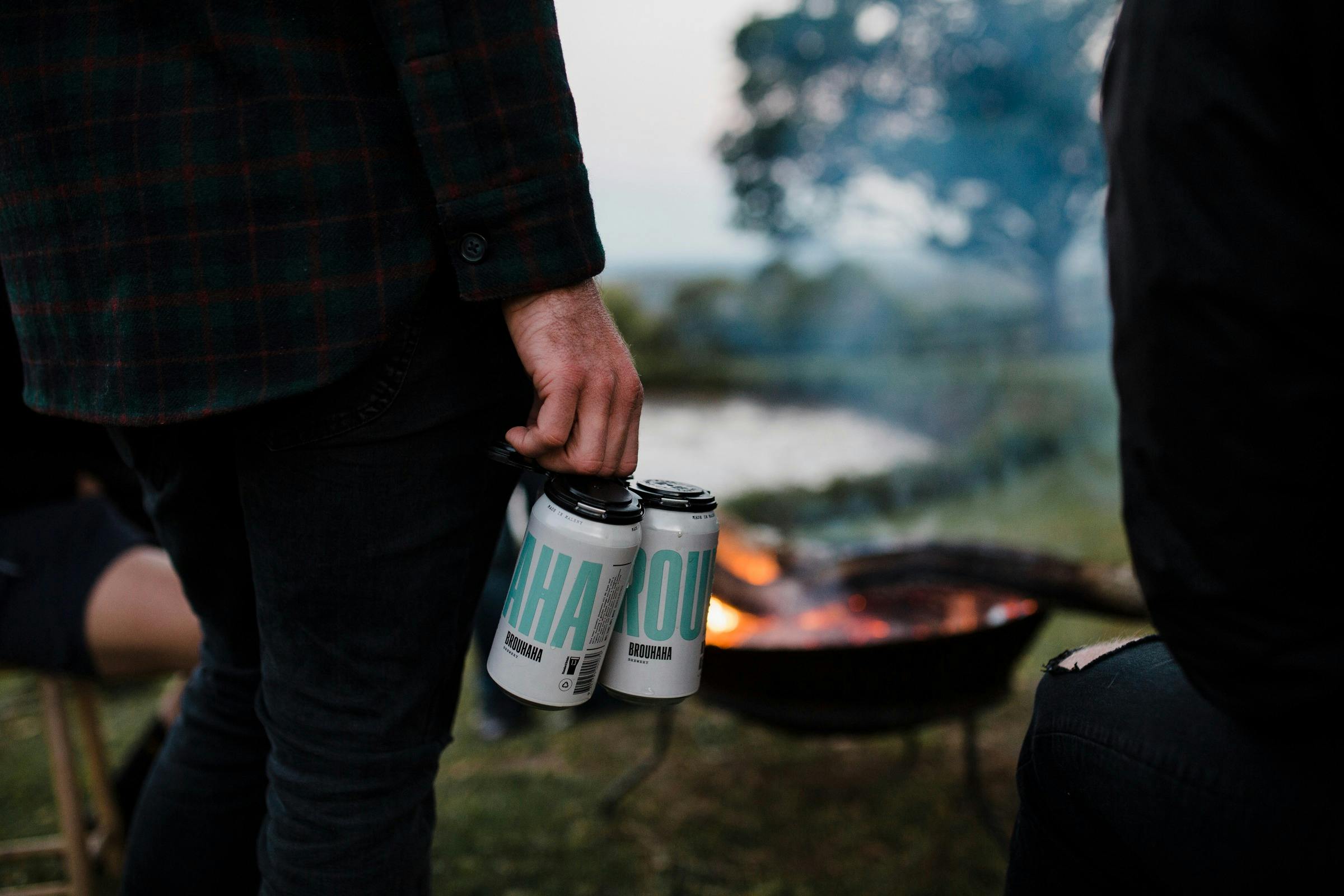 Person holding a four pack of Brouhaha's Hinterland Pale Ale