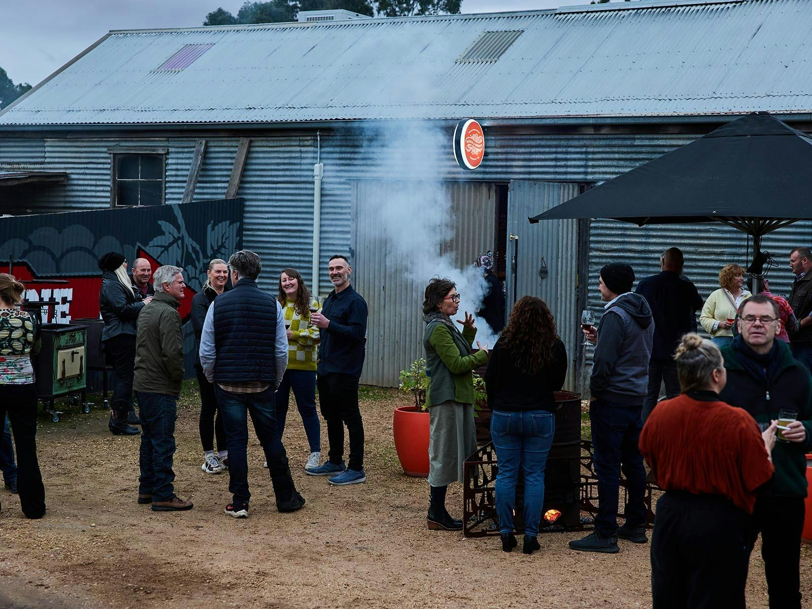 An event at the Black & Ginger Wine Shed, people standing outside celebrating