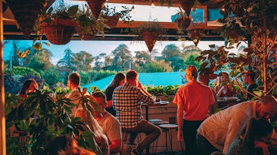 Group of people sitting watching sunset from upstairs bar