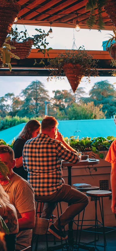 Group of people sitting watching sunset from upstairs bar