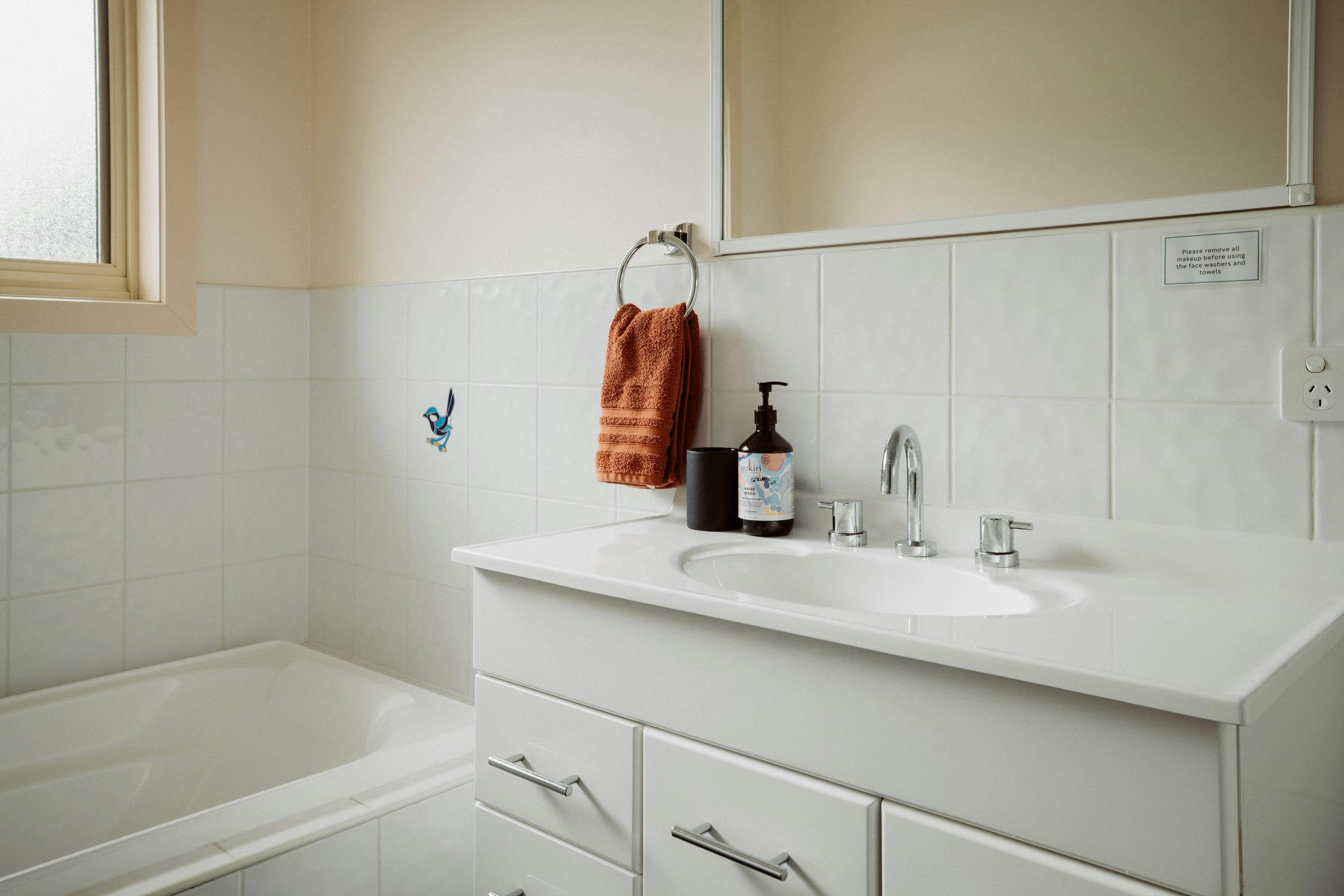 The bathroom includes a bathtub and shower. The toilet is located separately next to the bathroom