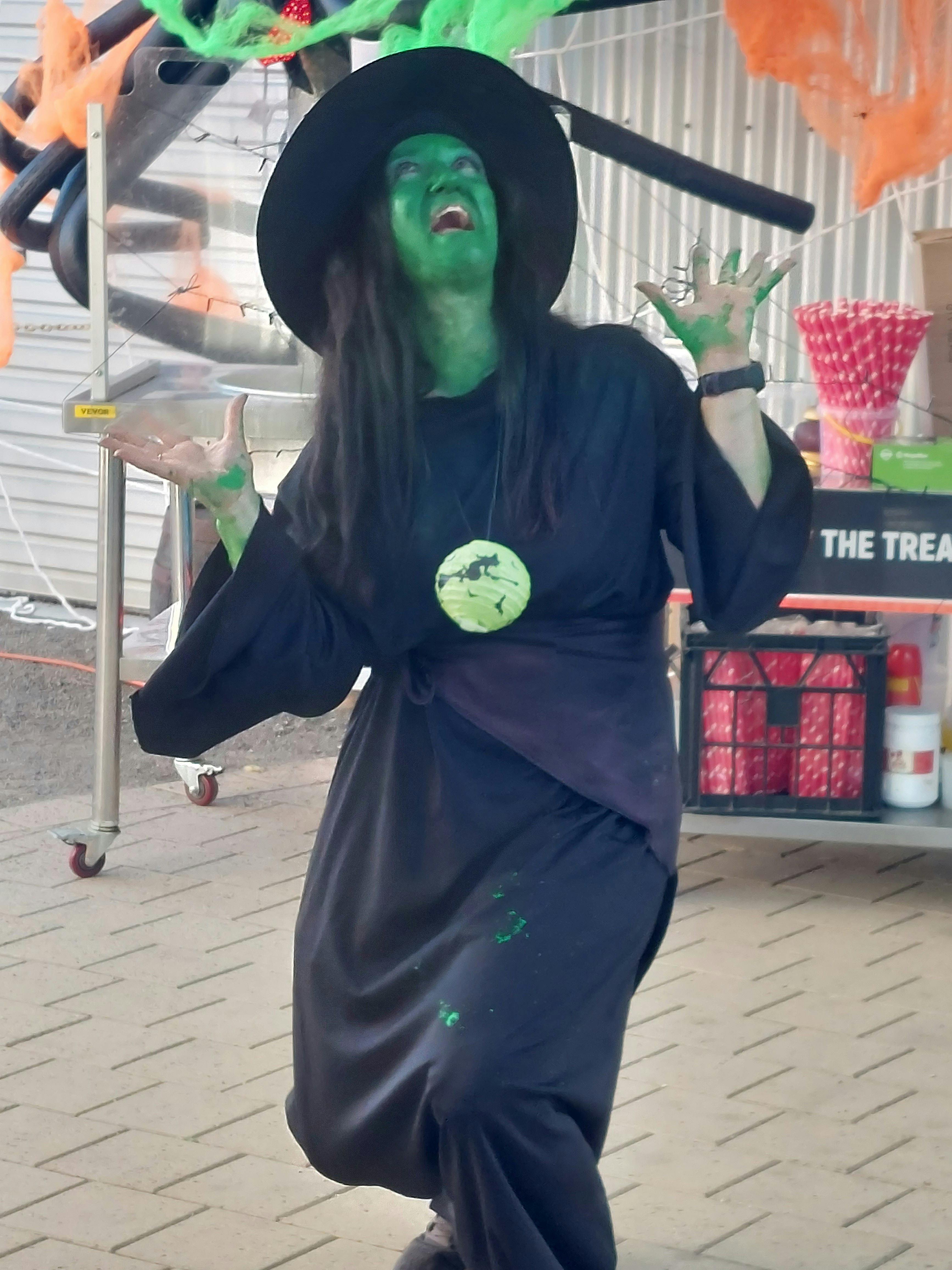 Staff in costume of witch with a terrifying surprise expression