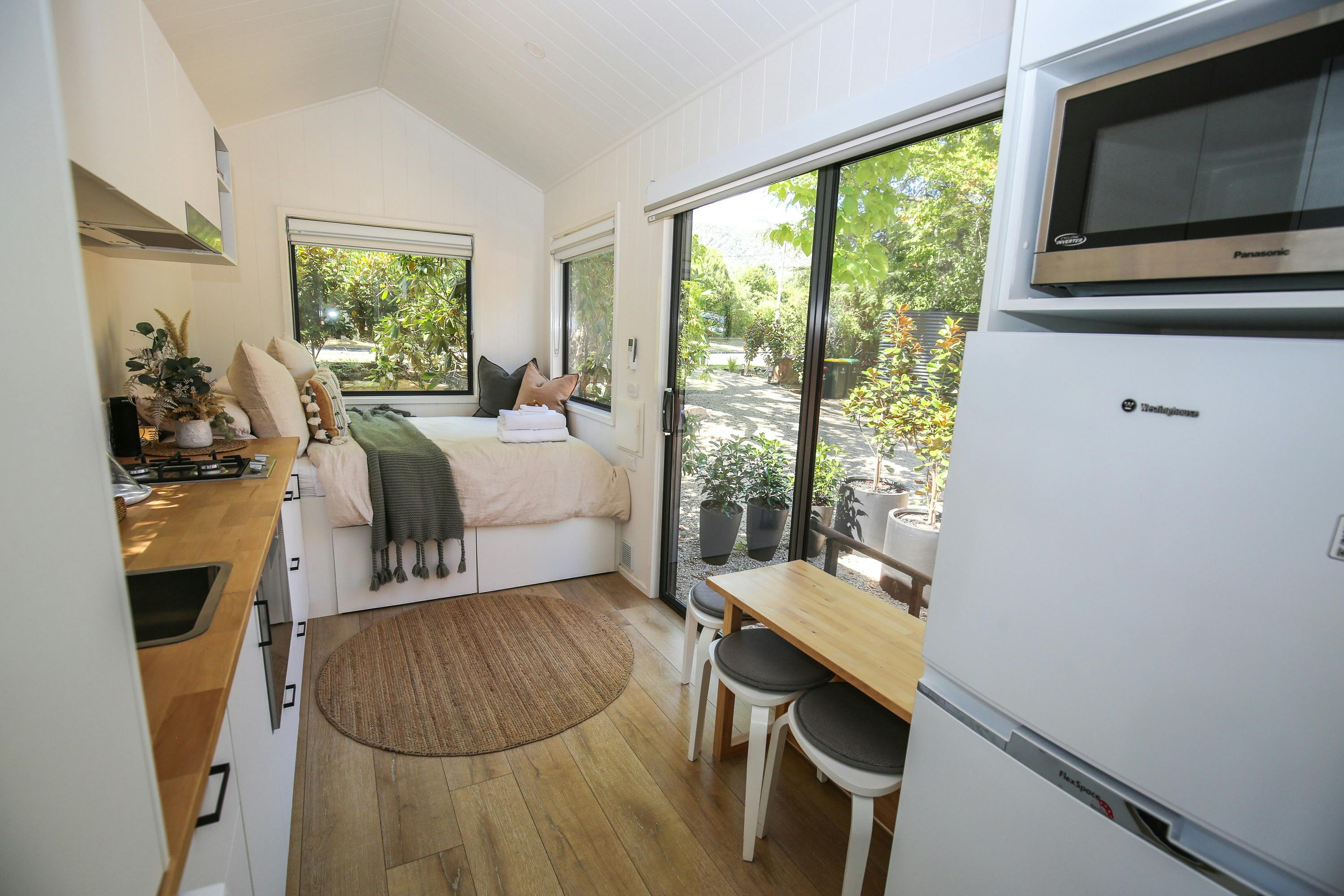 Maple Tiny Home featuring bed, dining space and kitchen