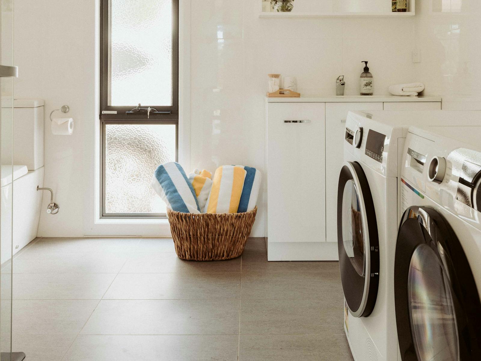 The bathroom is fully equipped with a washing machine, dryer, toilet, and a spacious walk-in shower.