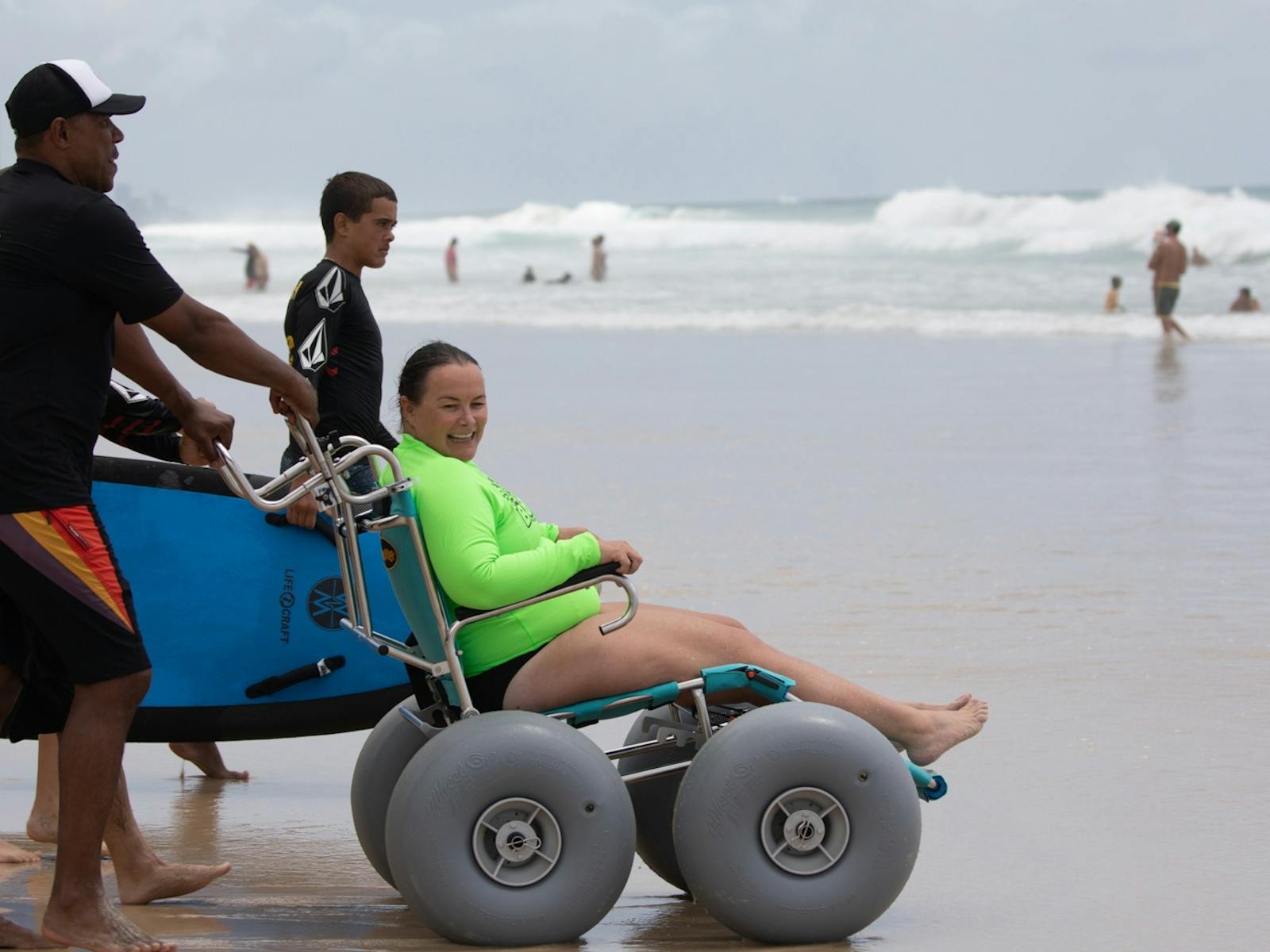 Woman smiles in beach wheelchair Woman smiles in beach wheelchair