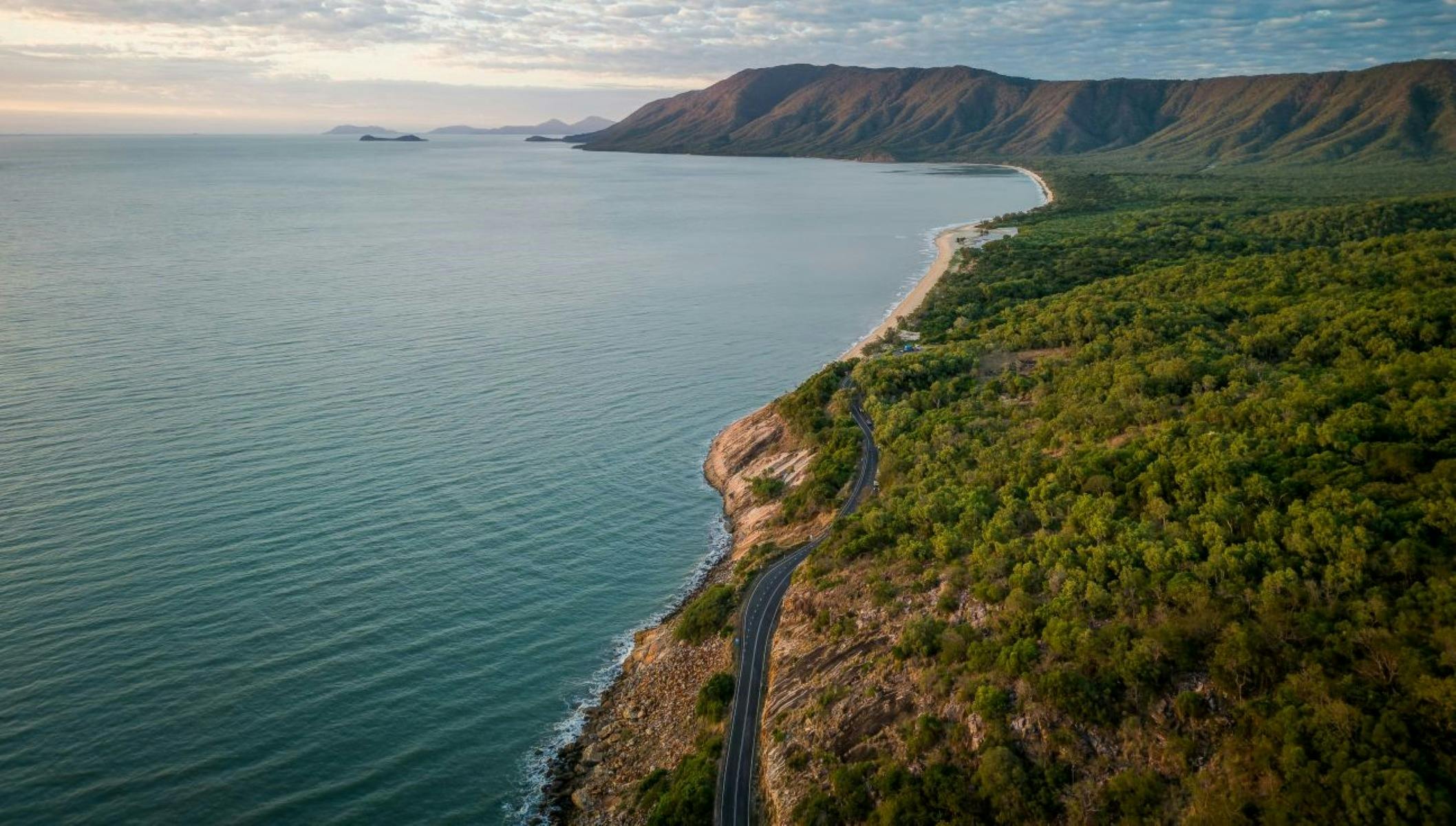 Aerial view of road following coastline.