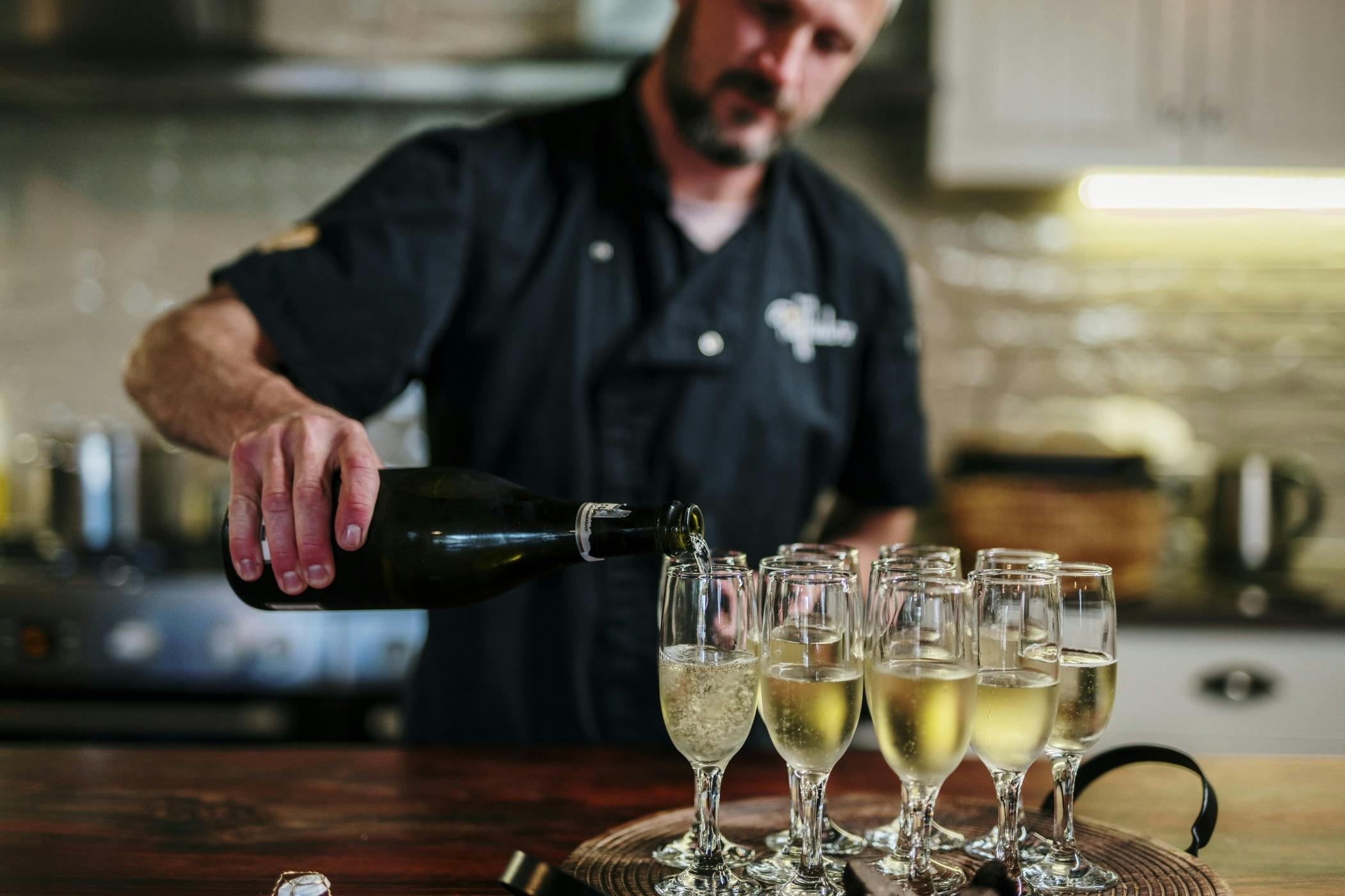 Timothy pouring sparkling wine into glasses
