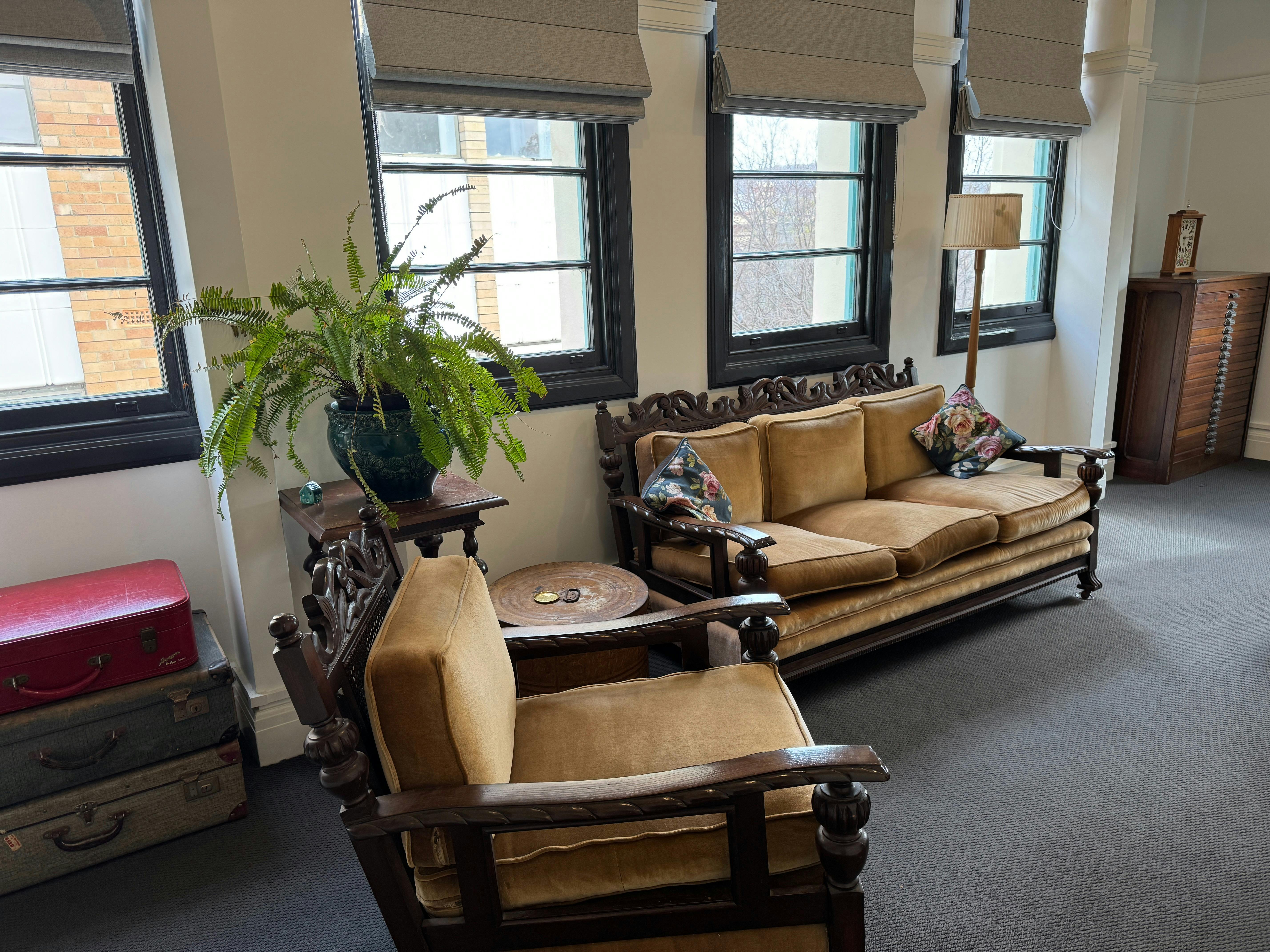 Old fashioned couch and a wall of windows face the TV
