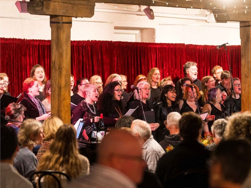 A group of people singing in front of an audience