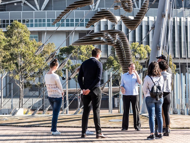 Tour group standing by the Sydney Olympic logo sculpture