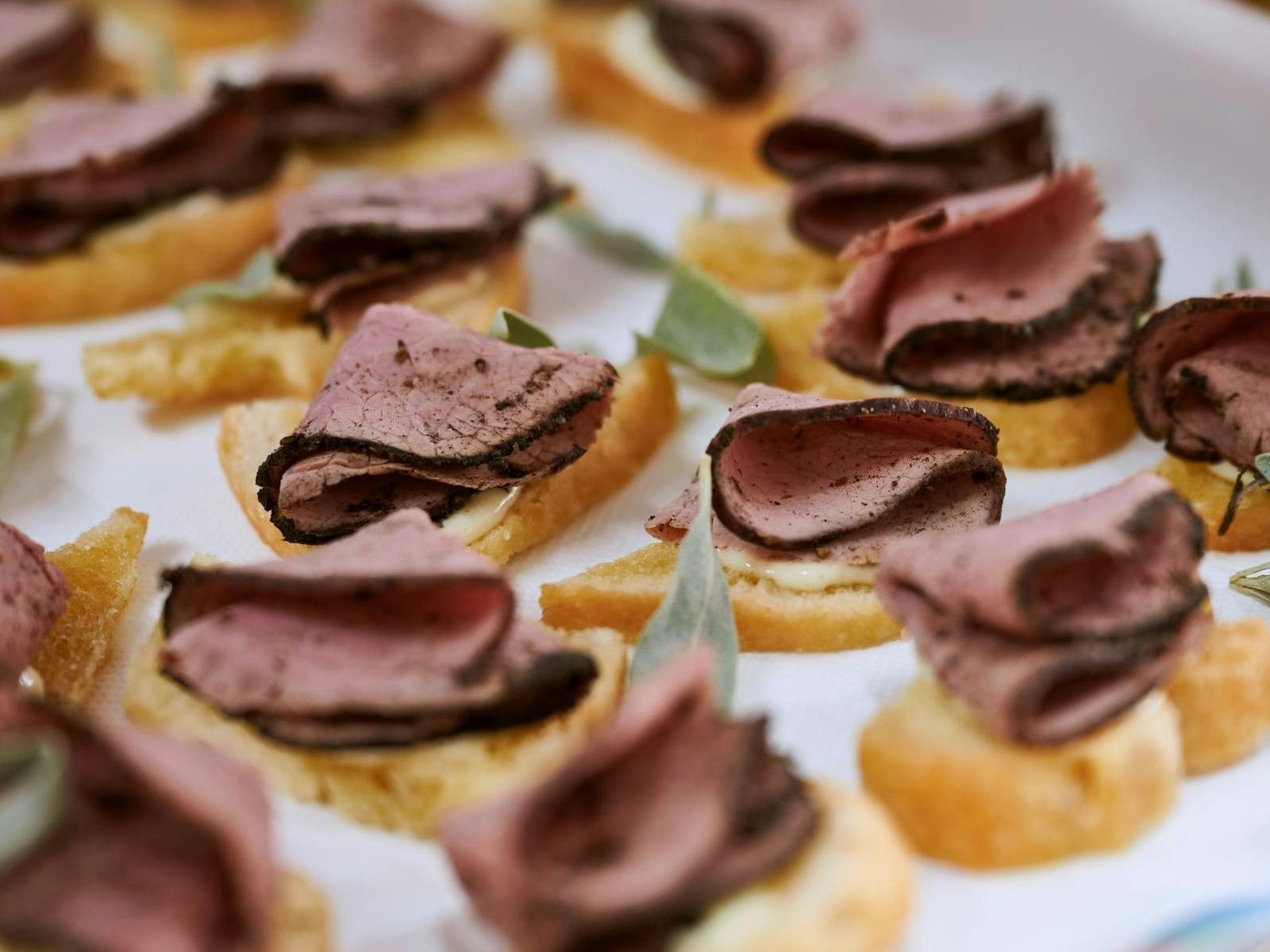 Beef is folded in bite sized pieces on crackers, ready to serve.