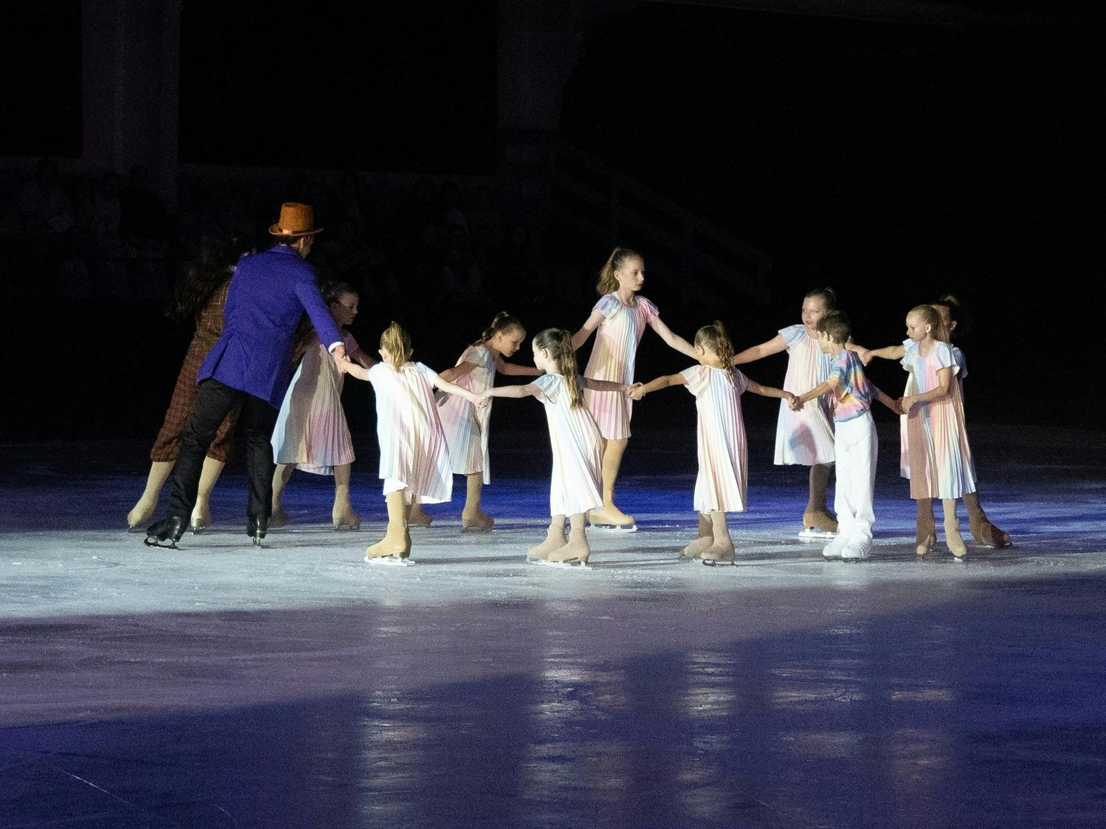 Little skaters in white having fun skating with higher ranked skaters