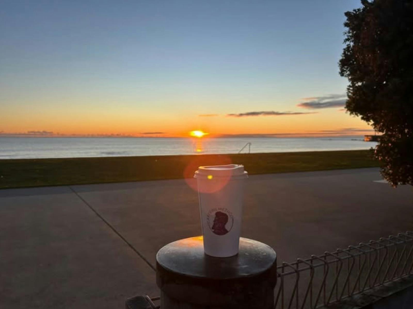 Takeaway coffee in front  of sunrise.