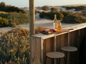 Luxury glamping deck with wine and grazing board overlooking Port Neill dunes