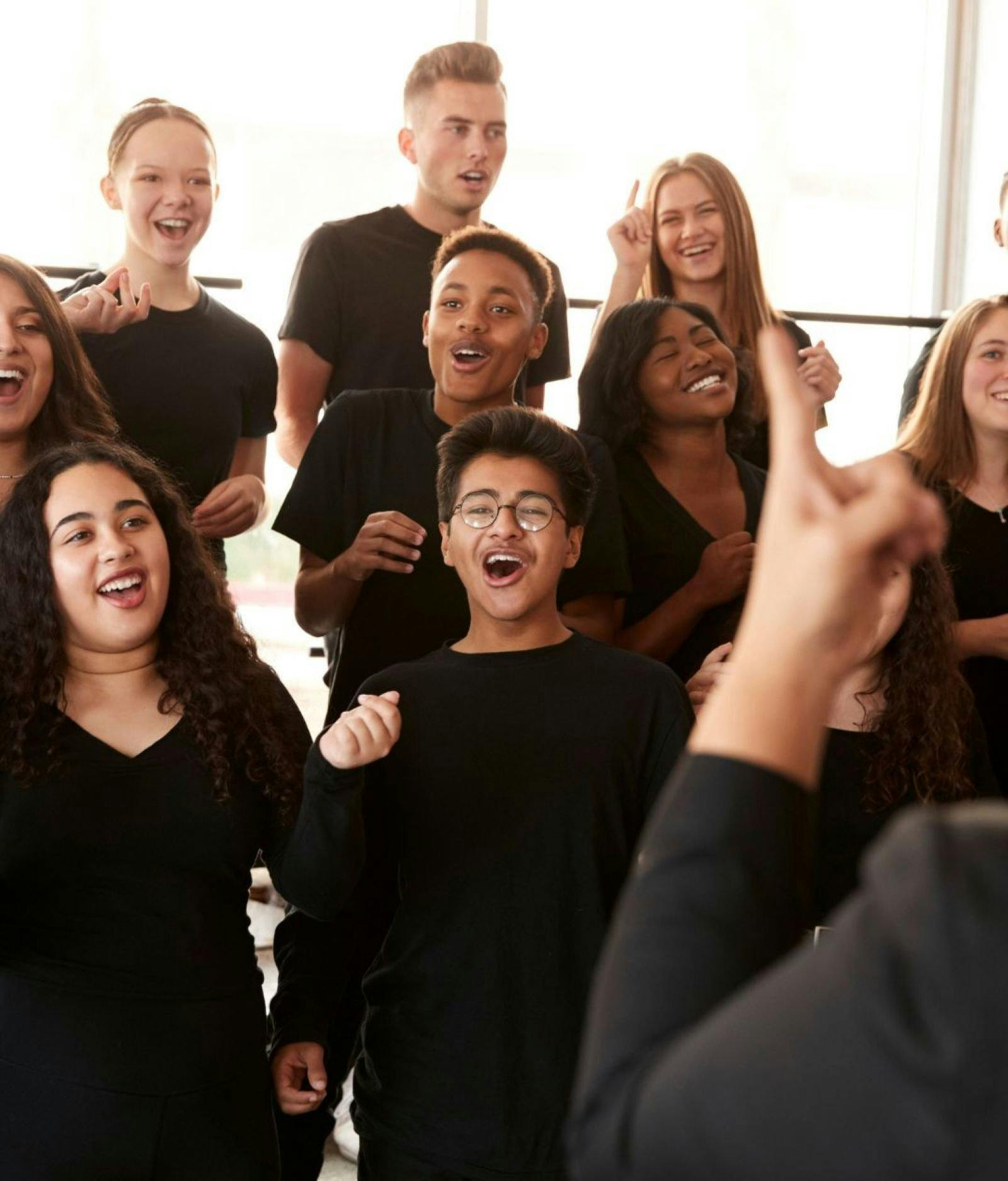 Young people happily singing and wearing black tshirts