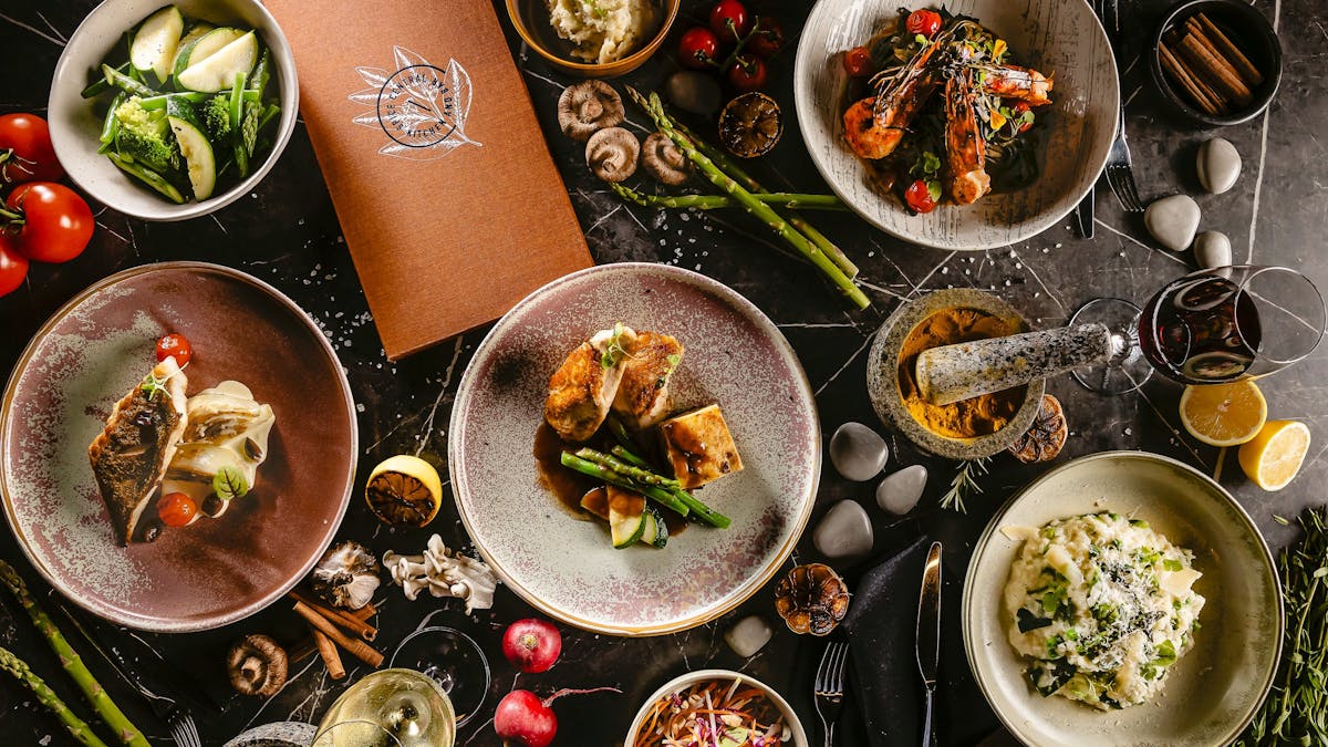 Top view of a table with different dishes and spices to showcase the new menu