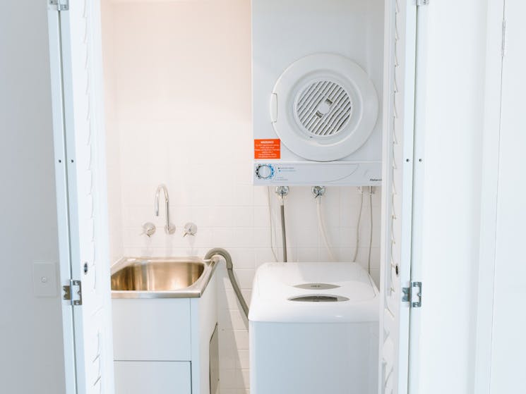 A laundry with washer, dryer and sink.