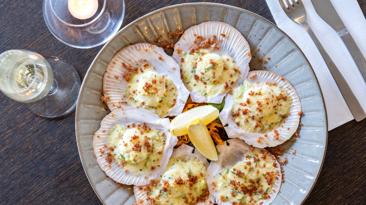 Sea scallops on ½ shell (6), lightly grilled with a garlic cream sauce and topped with chorizo crumb
