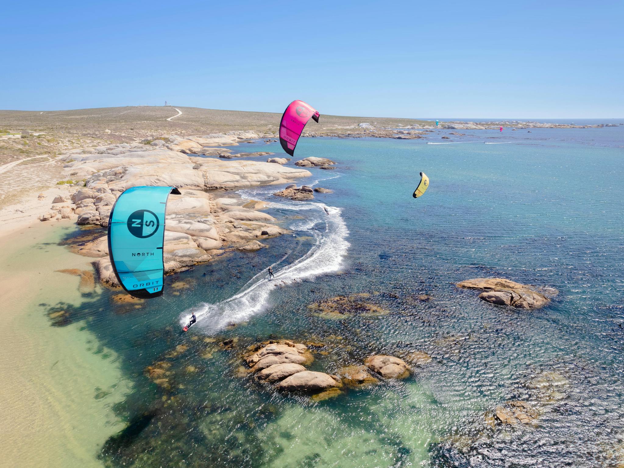 Aerial Photo of three kitesurfers in a beautiful clear water location Aerial Photo of three kitesurfers in a beautiful clear water location