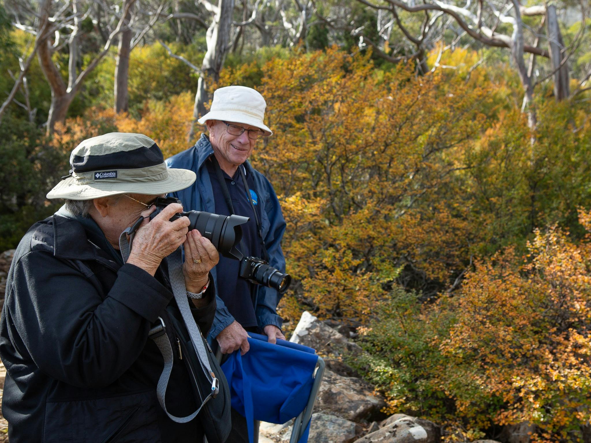 couple enjoying the fagus season - one with camera to eye taking photos