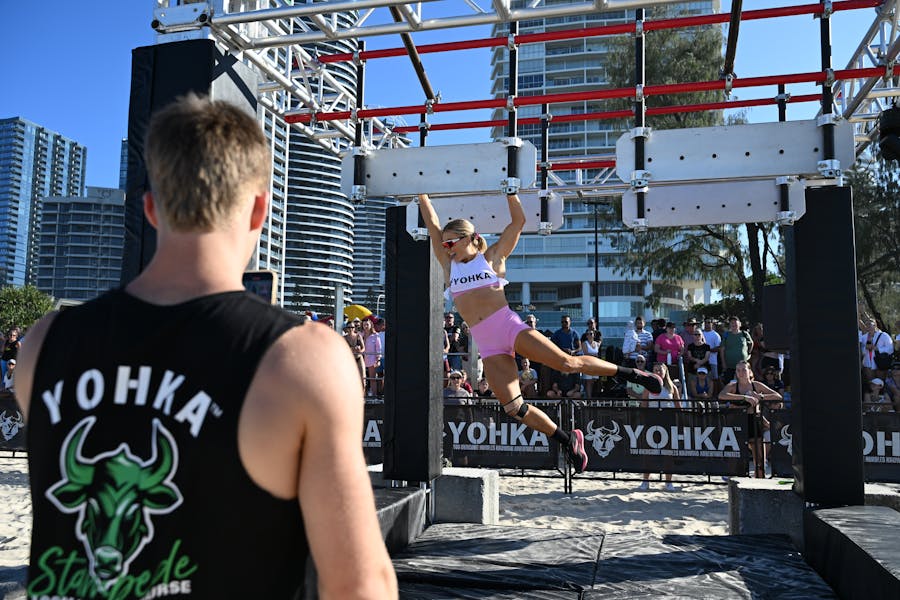 Female athlete swinging on an obstacle