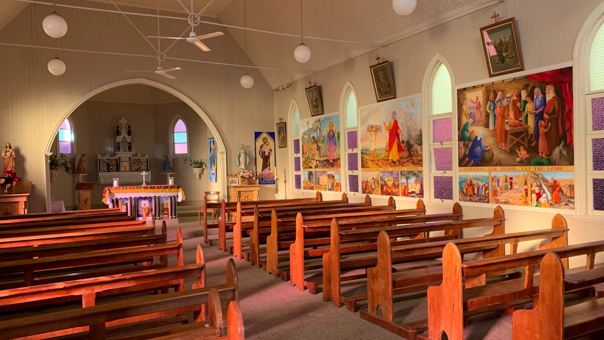 Interior of Bell Church lined with murals and stained glass windows.