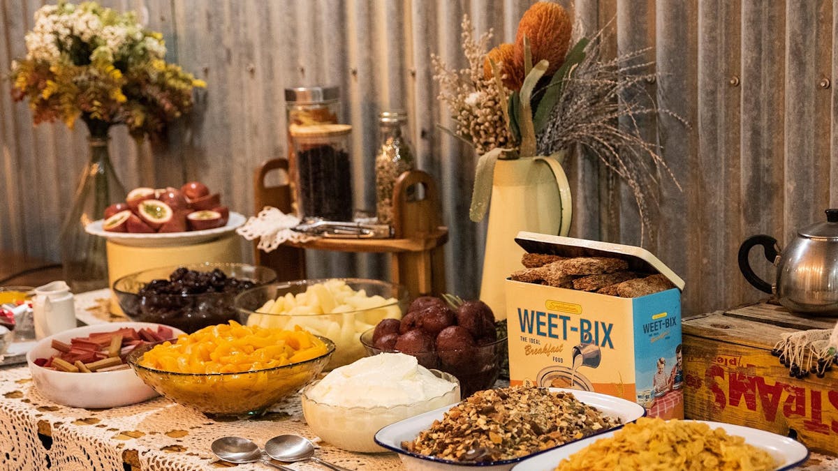 A breakfast buffet table filled with a selection of breakfast fruits and cereals