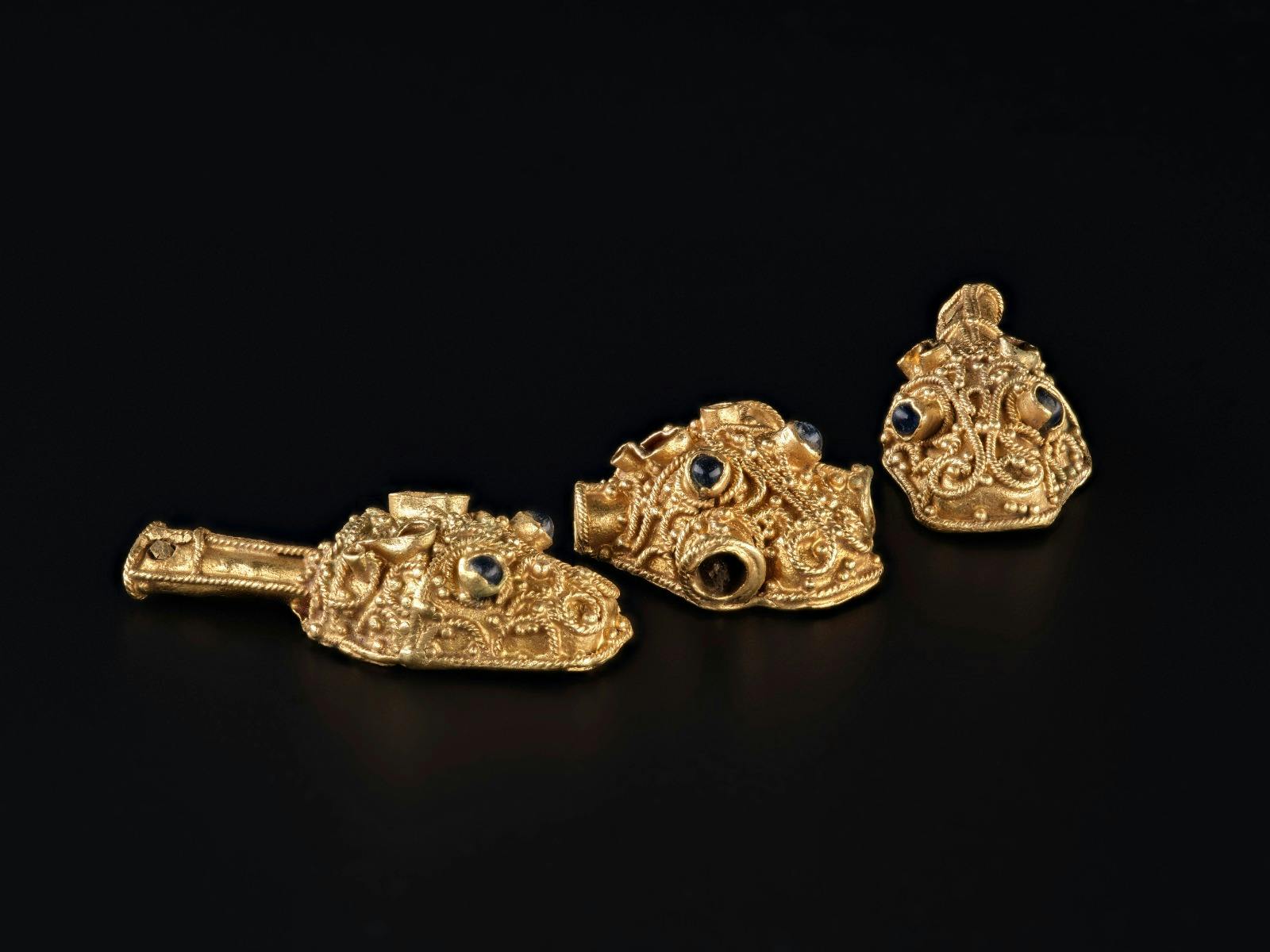 Three ornate gold mythical beasts with gemstone eyes