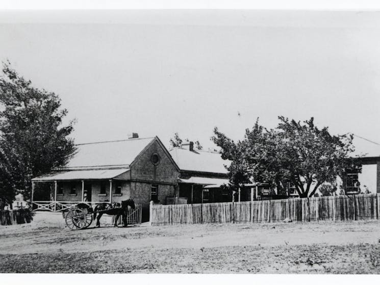 1862 Stone building with nurse on a verandan and horse and cart in front