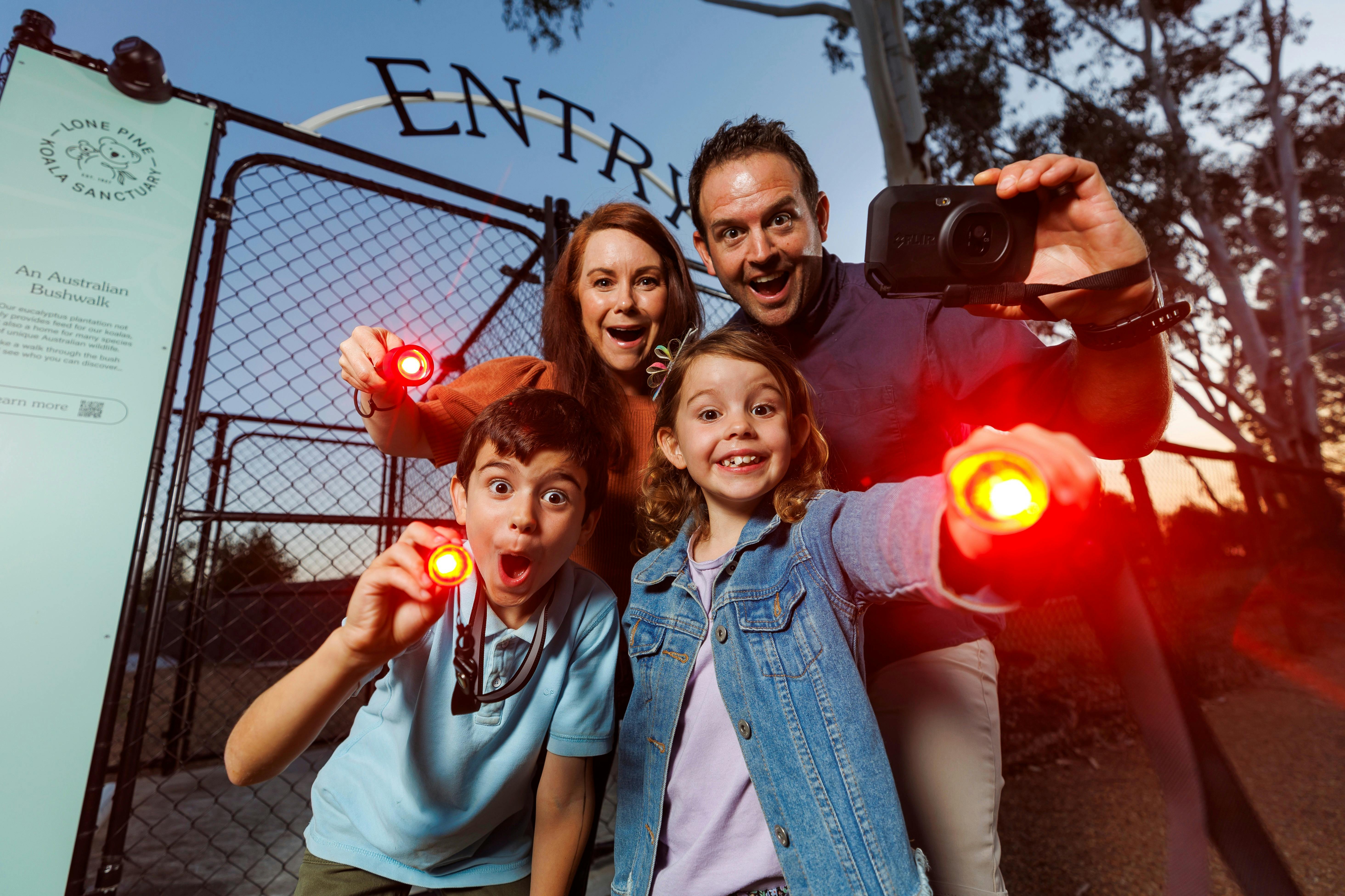 Family with red-light torches excited at the Nocturnal entry gates