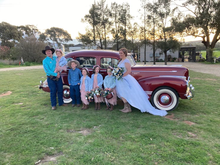 Brides family in front of red Car