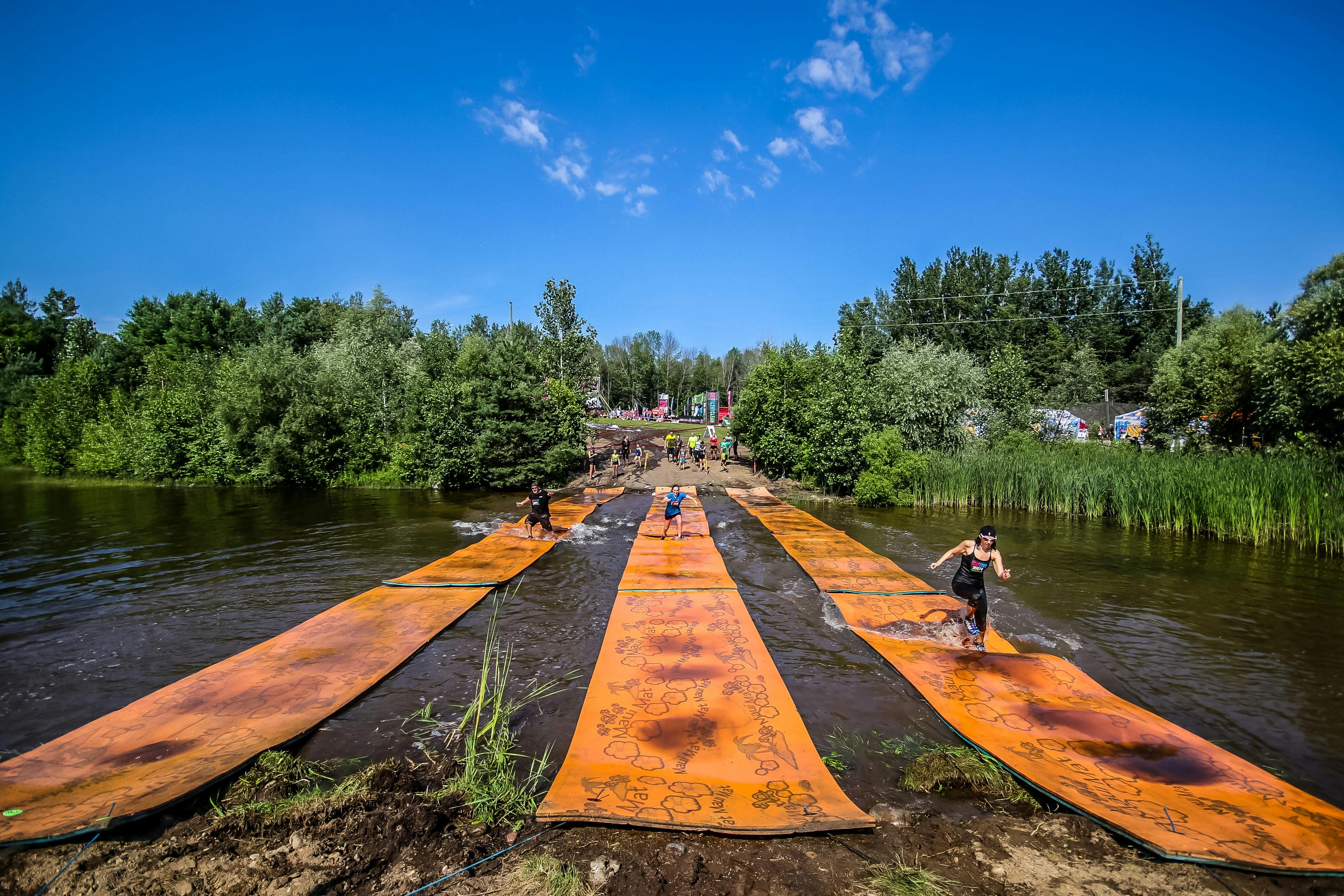 People running over the lily pad obstacle